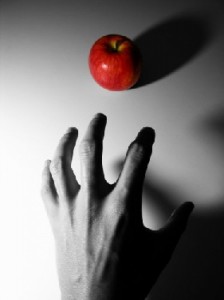 Monochrome_hand_reaches_for_red_apple