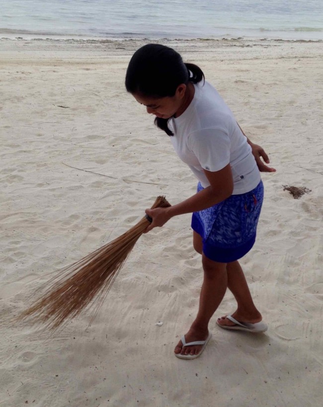 Woman sweeping with a short handled broom